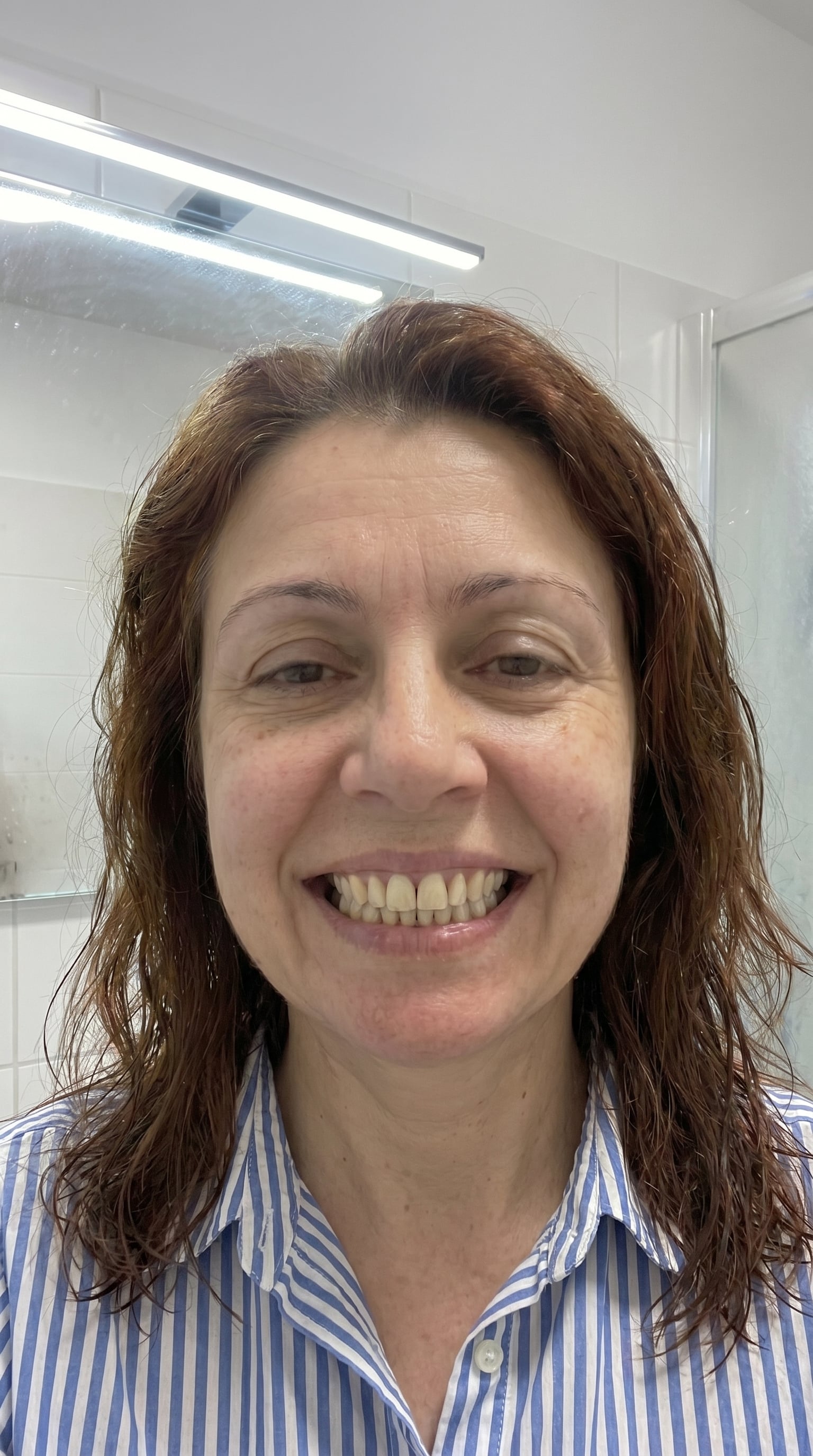 Ileana, 54 ani, Cluj — după rutina Bright White: baie cu faianță albă, lumină naturală, zâmbet larg cu dinți vizibil mai albi
